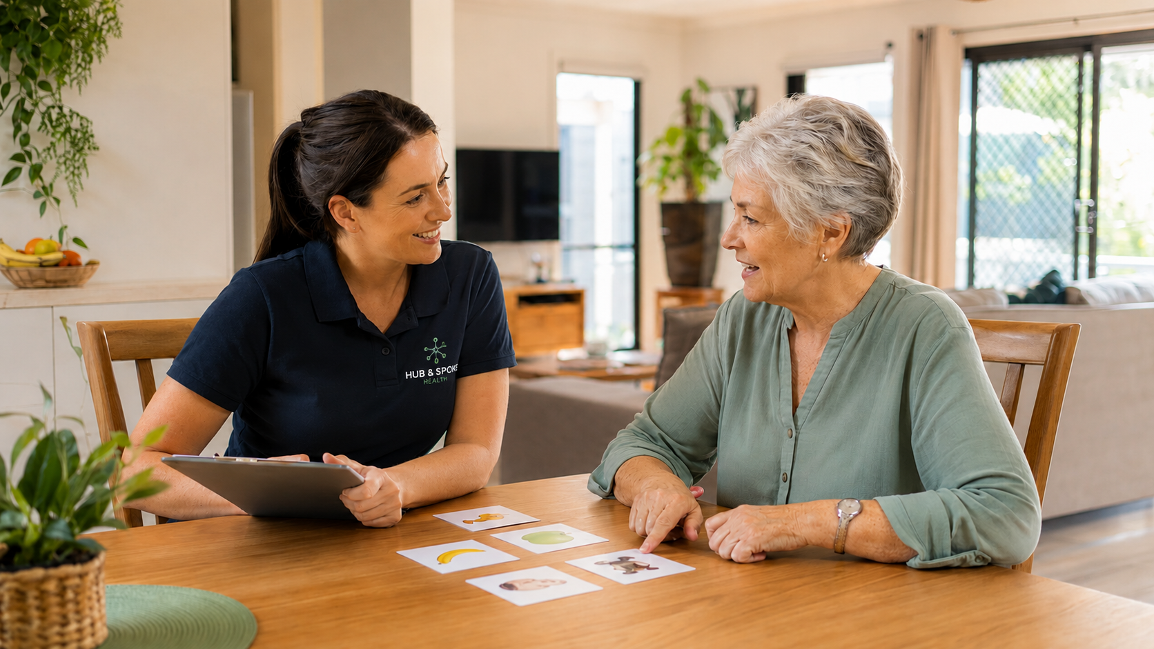 Mobile speech pathologist guiding an adult client through a communication exercise together at home